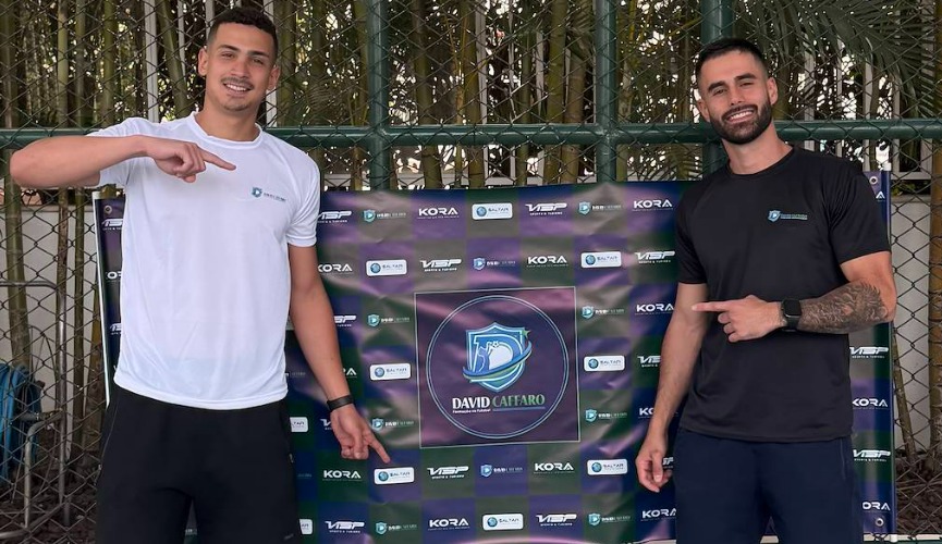 Treinadores da formação de futebol David Caffaro em frente ao banner com a marca da $altar